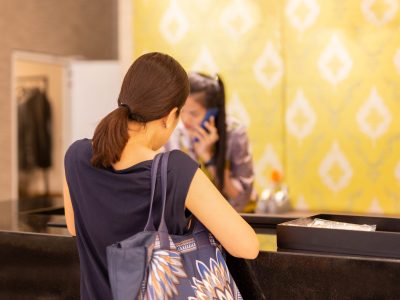 Woman at checkout in clothing store with staff on the phone enquiry