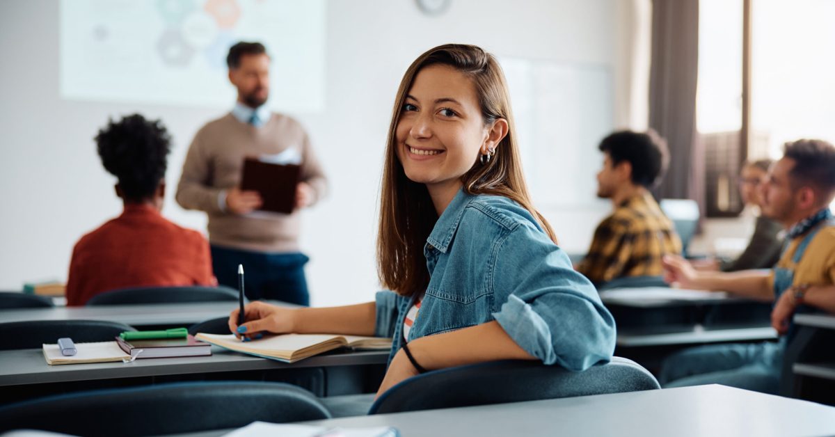 Happy female student during class at the university looking at camera.