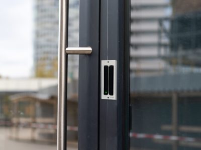 The front door of a office block, reflecting buildings in the glass.